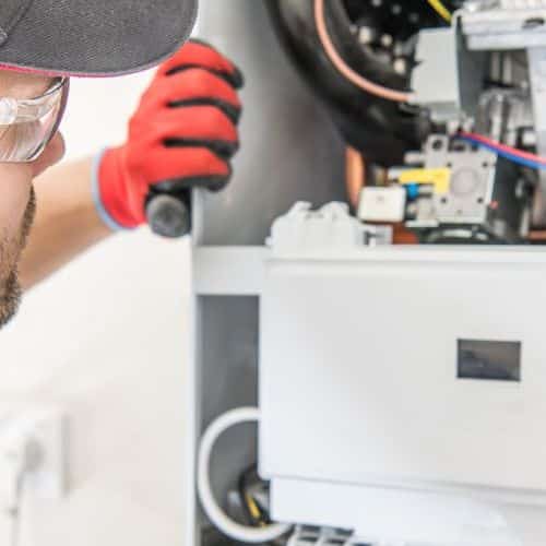 HVAC Technician Examines System.