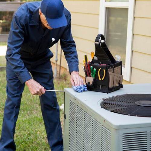 An HVAC Technician Maintains an Air Conditioner.